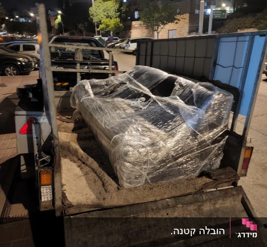 ספה עטופה בניילון על עגלה להובלה